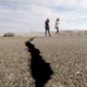 People crossing Highway 178 next to a crack left created by the Ridgecrest earthquake in July.